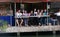 A group of people wave from the edge of the canal at Amphawa Floating Market