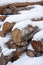 Group of piled firewood in winter with snow on top