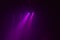 A group pink rays from spotlights on a dark background on a concert show