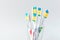 Group of plastic white toothbrushes in different colors in glass on white background.