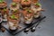 Group of portions of Classic tiramisu dessert in a glass cup on stone board on concrete background