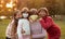 Group portrait of children in protective medical masks walking on street on sunset