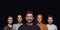 Group portrait of emotional people on black studio background