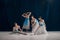 Group portrait of four ballerinas in classic white tutus and blue ribbons performing graceful ballet routine on scene.
