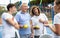 Group portrait of four padel players of different ages standing at tennis court at fitness health club