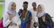 Group portrait of happy African students standing together against white background girls wearing traditional Sudan