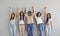 Group portrait of happy confident diverse young women standing together and holding hands