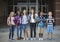 Group portrait of pre-adolescent school kids smiling in front of the school building