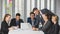 Group portrait of six business people team sitting and talking in conference together in an office with intimate and unity manner