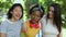 Group portrait of three multiracial female friends laughing outdoors