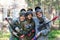 Group portrait of three smiling paintball players outdoors