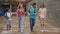 Group of positive cheerful teenagers hanging out on streets of city on summer day