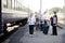 Group of positive elderly seniors people with face masks waiting train before traveling during a pandemic