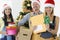 Group of postmen in red santa hats holding letters and boxes with gifts