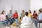 Group of pregnant women with men and doctor at courses for expectant parents indoors