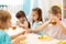 Group of preschool children have a lunch in daycare. Kids eating healthy food in kindergarten