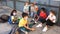 Group of preteen children in face masks resting outdoors in schoolyard during break in lessons. Back school concept