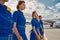 Group of pretty air hostesses crossing the airfield