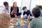 Group of primary school children study and play together in classroom with teacher, diverse students sit on floor while do