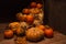 A group of pumkins of different shapes, collected into nice central composition, surrounded by dry straw, leaves on the wooden