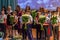 Group of pupils and there parents standing on the stage and congratulating  for another one. Festive students holding flowers.