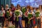 Group of pupils and there parents standing on the stage and congratulating  for another one. Festive students holding flowers.