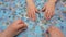 A group of puzzles, hands on a blue surface background. Puzzle game, Preschool education. Family pastime concept