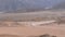 Group on quad bike rides through the desert in Egypt on backdrop of mountains. Driving atv\'s.