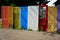 Group of random colorful doors being used as decorative yard fence.