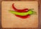 Group of red and green narrow long spicy peppers on the board