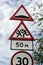 Group of red and white road signs against dramatic sky