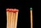 Group of red wooden matches standing with green match