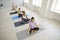 Group of relaxed ladies doing breathing exercise and meditating on yoga mats at gym