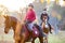 Group of rider girls riding their horses in park