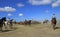 Group of riders gathering a herd of horses