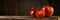 Group of ripe fresh tomatoes on old boards against a brown wooden backdrop. panoramic side view. artistic still life in simple