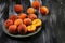 A group of ripe peaches on a plate. dark background. Fresh peach concept. Flat lay. Copy text