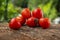 Group of ripened tasty red raw strawberry tomatoes on wood on green natural background, tasty healthy vegetables still life