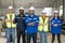 Group of robotic engineers wear helmets safety standing and arms crossed at factory workshop. Technician professional team robot