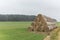 Group of rolled straw bales stacked in a pyramid form pile outdoors in the Czech Republic. Cattle feed. Autumn foggy day
