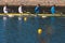 Group of rowing team athletes sculling during competition, kayak boats race in a rowing canal, regatta in a summer sunny day,