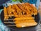 A Group of Sausage Satay Being Cooked Over a Black Hot Pan