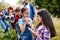 Group of school children with teacher on field trip in nature, learning science.