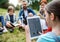 Group of school children with teacher and windmill model on field trip in nature.