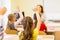 Group of school kids raising hands in classroom