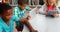 Group of school kids using digital tablet and laptop in library