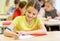 Group of school kids writing test in classroom