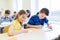 Group of school kids writing test in classroom