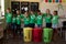 Group of schoolchildren holding color coded recycling bins and bags  in an elementary school classro