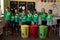 Group of schoolchildren holding color coded recycling bins and bags  in an elementary school classro